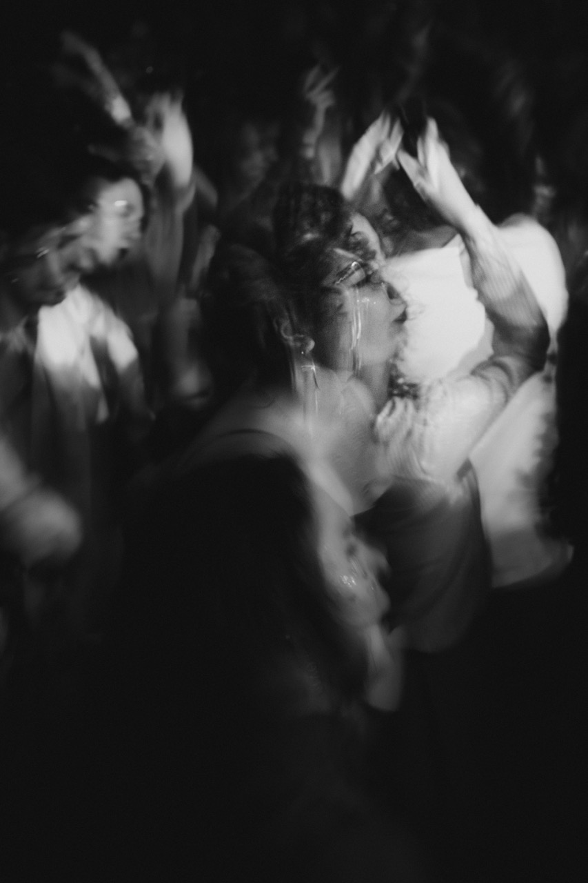 Personnes en mouvement dansant librement, image floue en noir et blanc évoquant le body shaking, la libération corporelle et l’énergie du vivant.